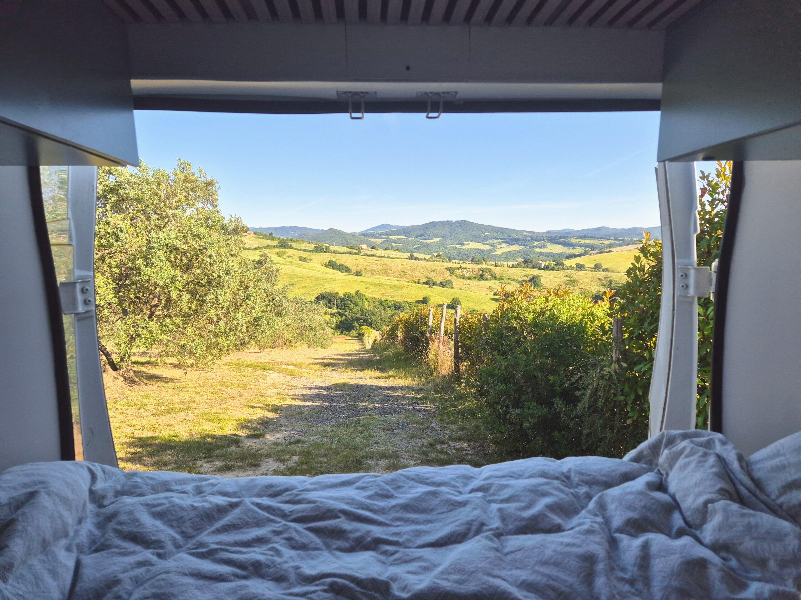 Uitzicht camper Toscane vanuit het bed met achterdeuren open
