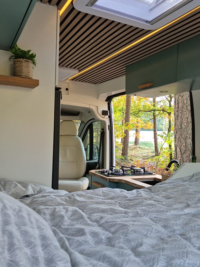 Camper Jade vanaf bed richting het keukenblok de bossen in kijkend