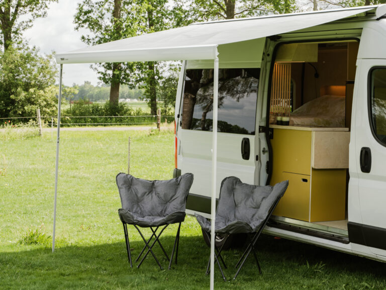 Loungestoelen onder de luifel bij de camper