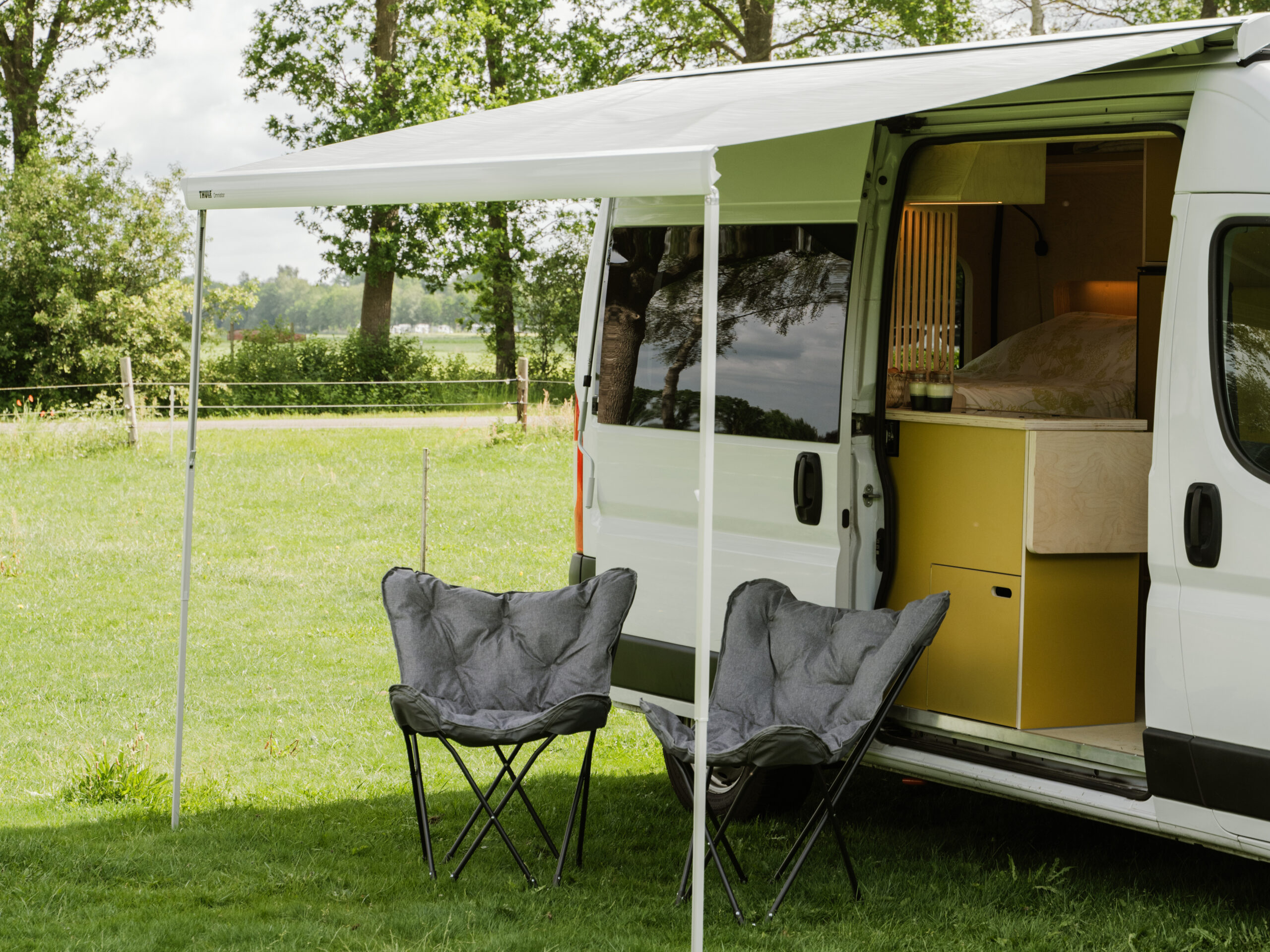 Loungestoelen onder de luifel bij de camper