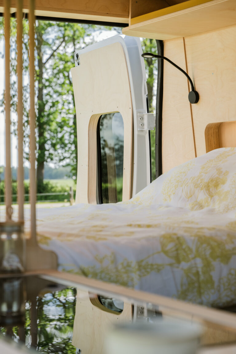 Berken camperinbouw met bed en fleurige kleuren